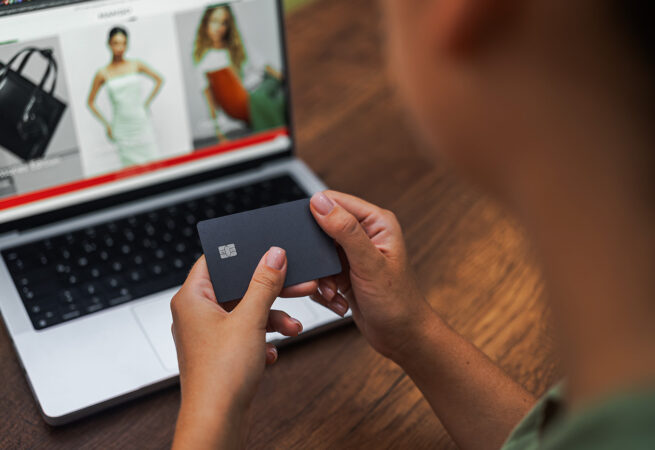 hands-hold-credit-card-against-laptop-screen-onlin-2024-11-27-18-57-29-utc